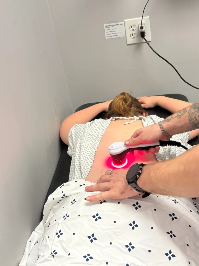 Credence Chiropractic provider applying Aspen laser therapy to a patient's lower back